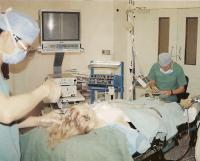 Хирург зачесывает волосы назад и вводит местный анестетик в область лица