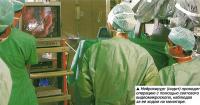 Нейрохирург (сидит) проводит операцию с помощью светового видеомикроскопа