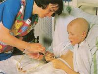 Сестра проводит внутривенную химиотерапию мальчику с лейкозом